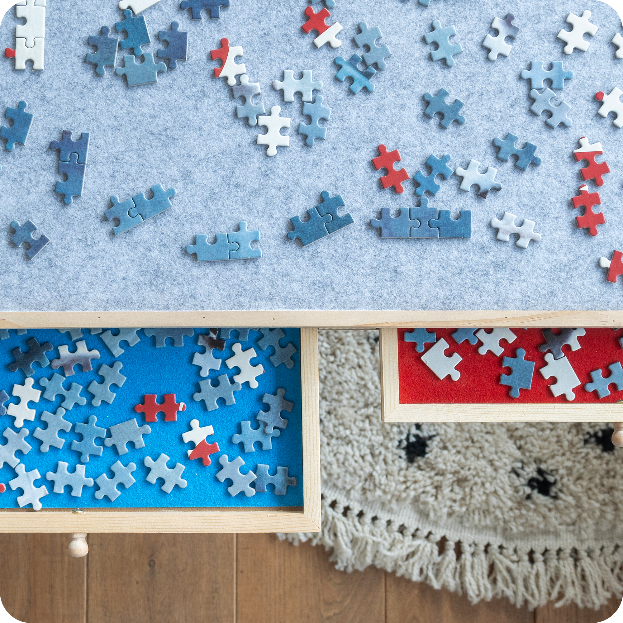 Gedetailleerd aanzicht van de puzzelplank waar de twee lades zijn uitgeschoven en deze zijn gevuld met puzzelstukjes.